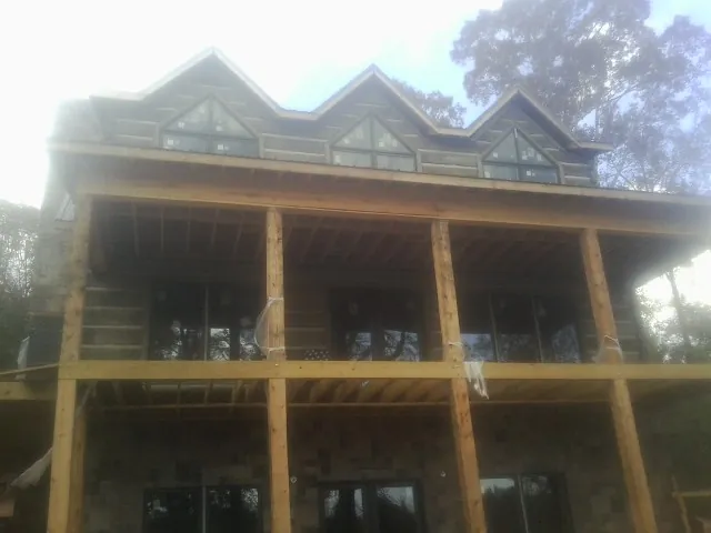 Dormers and porch framing on a large log home under construction — Roof Coating work by our crew in Basalt